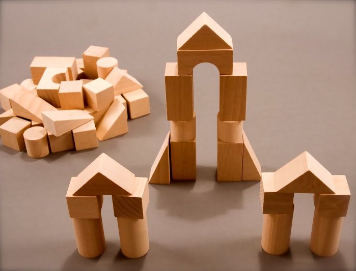 Anak menyusun balok bangunan untuk melatih kreativitas dan motorik halus.